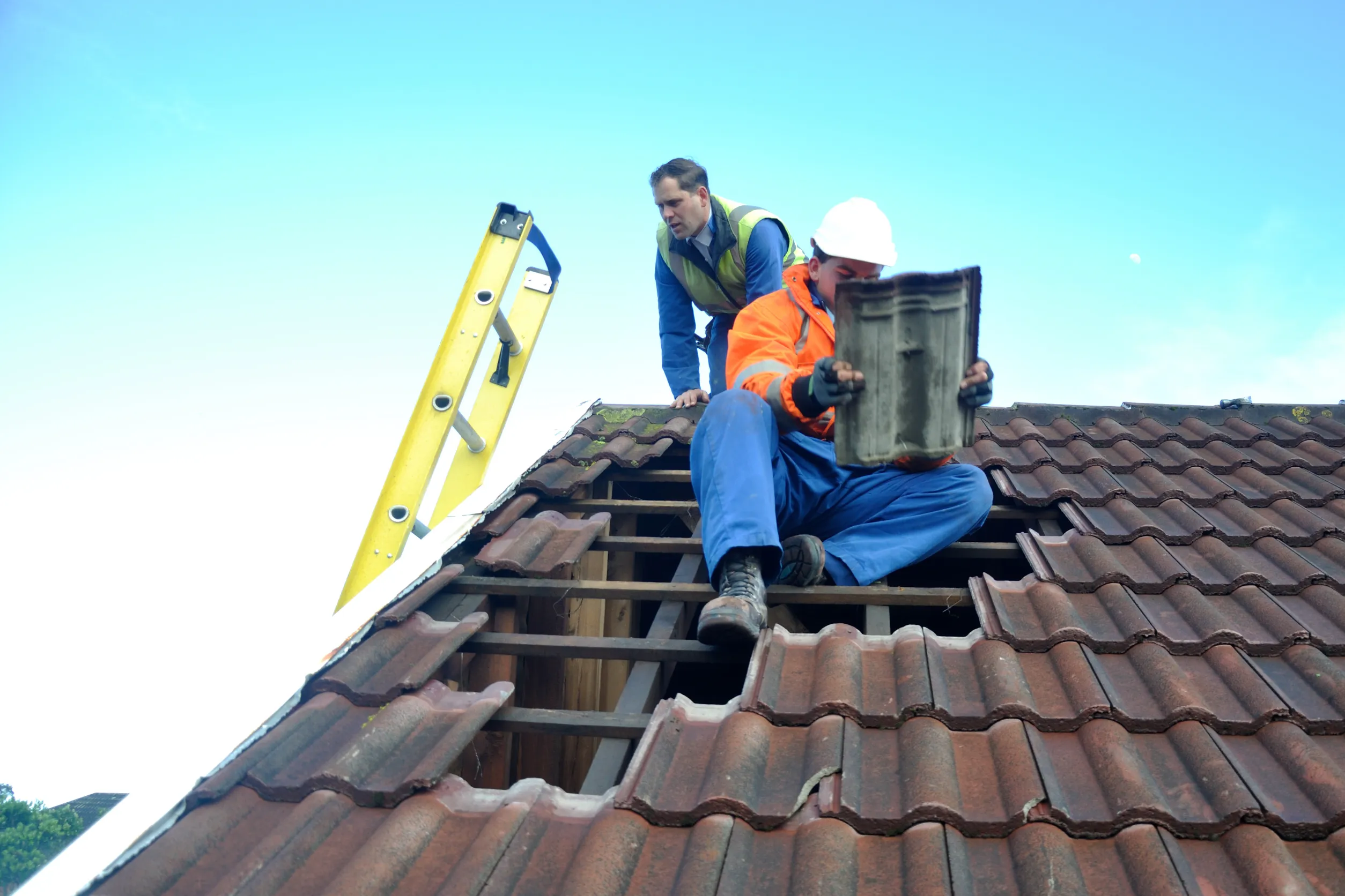 Image of a Roofing contractor repairing a roof shingles